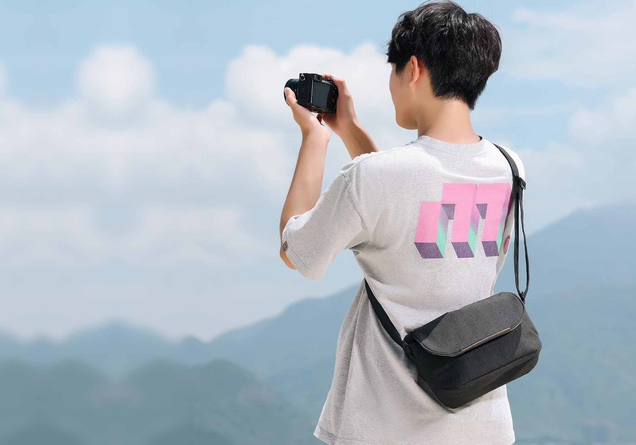 A photographer framing a mountain view with a camera